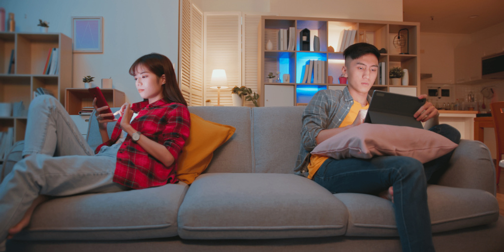 Pareja mirando redes sociales sin hablarse